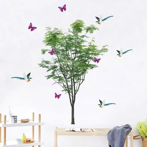 Detailed close-up of green tree and bird wall stickers in a modern living room