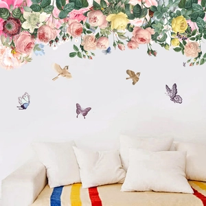 Wall stickers featuring flowers, butterflies and birds above a minimalist white sofa