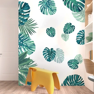 Tropical monstera and palm leaf wall stickers in a modern minimalist living room setting