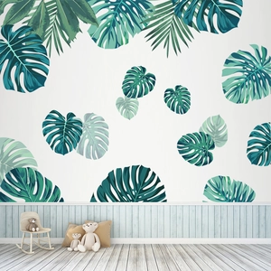 Tropical monstera and palm leaf wall stickers in a modern minimalist nursery room setting