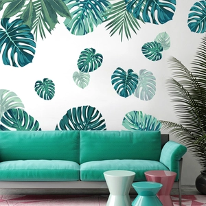 Tropical monstera and palm leaf wall stickers in green and teal on a white living room wall