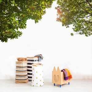 Close-up of leafy tree branch wall sticker above Nordic wooden toy storage box