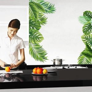Detail showing tropical monstera and palm leaf wall stickers in a modern kitchen setting