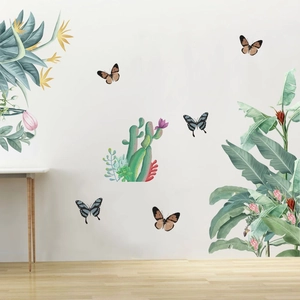 Detail of tropical plant wall decals featuring green cacti and butterflies on a white wall