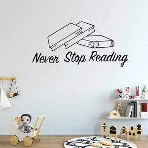 Black 'Never Stop Reading' vinyl wall decal with book design in a cozy nursery room