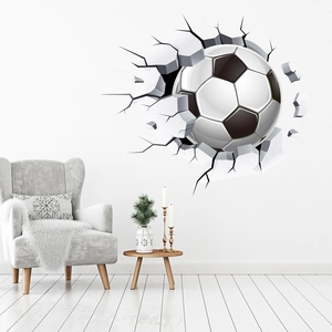 3D cracked wall football sticker shown on a white wall above a modern grey armchair