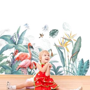 Tropical wall decals featuring pink flamingos and green monstera leaves in nursery