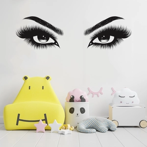 Detailed wall sticker showing elegant black long eyelashes and brows on a clean white wall