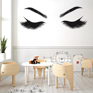Detailed close-up of vinyl eyelash wall sticker applied on a white wall in child room