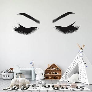 Detail of minimalist black eye lashes wall decal in a cozy Nordic nursery decor