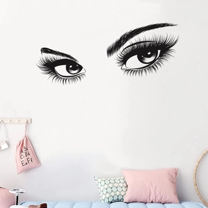 Detail view of black vinyl wall sticker featuring long eyelashes and brows in a bedroom