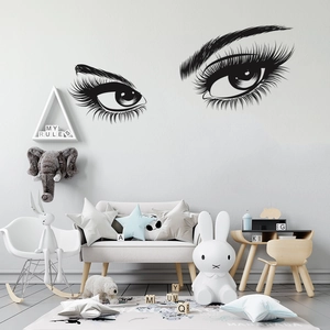 Close-up of black vinyl eyelash wall decal in a cozy Nordic style bedroom setting