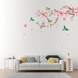 Detail of vinyl wall stickers featuring pink cherry blossoms and blue birds on white wall