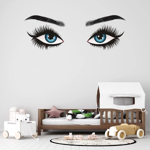 Close-up of stylish eyelashes and blue eyes wall decal in a cozy bedroom setting