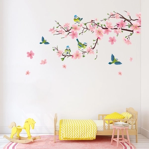 Pink cherry blossom tree wall decal with colorful birds in a cozy kids room setting