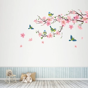 Detail of pink cherry blossoms and birds wall decal in a cozy children room setting