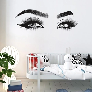 Detail of black vinyl wall sticker showing eyes with long lashes on a white bedroom wall