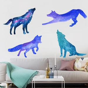 Modern star galaxy wolf wall decals displayed on a living room wall behind a gray sofa