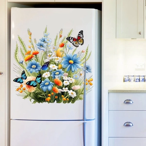 Autocollants muraux floraux avec marguerites bleues et papillons sur un réfrigérateur blanc