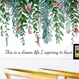 Detail of green plant wall decal with red berries and cursive dream life lettering