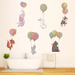 Detail of cartoon animals on wall stickers floating with balloons in a cozy bathroom decor