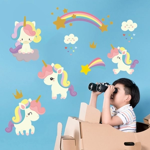 Détail de stickers muraux licorne arc-en-ciel pour chambre d'enfant avec un garçon qui joue