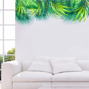 Lush tropical green palm leaf wall decals displayed above a white sofa in a modern room