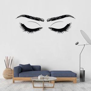 Modern wall sticker featuring beautiful eyelashes and brows above a blue sofa