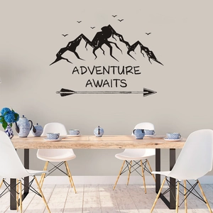 Detail view of mountain and arrow wall decal with 'Adventure Awaits' text in dining room