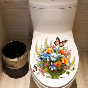 Détail des stickers fleurs et papillons colorés sur le couvercle des toilettes blanches