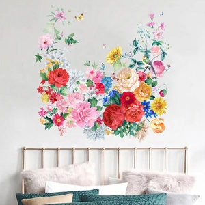 Vinilos decorativos con peonías, rosas y mariposas sobre una cama en el dormitorio