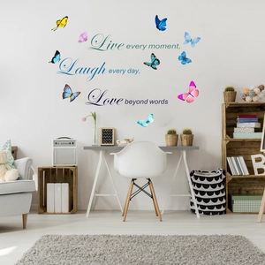 Detail of live laugh love wall decals with colorful 3D butterflies on a white wall