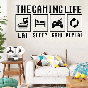 Detail of Eat Sleep Game Repeat wall decal on a beige wall above a cozy living room sofa