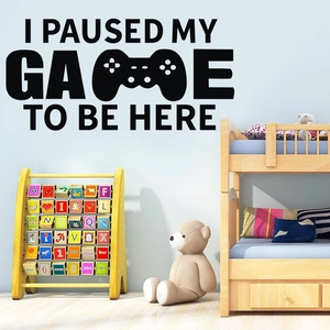 Détail d'un sticker mural noir de manette de jeu vidéo dans une chambre d'enfant