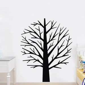 Close-up of a black tree vinyl wall decal on a white wall in a bedroom setting