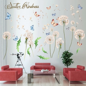 Macro view of dandelion and butterfly wall stickers on white wall above a red sofa