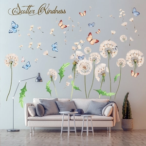 Detail view of dandelion and butterfly wall stickers with Scatter Kindness quote on gray wall