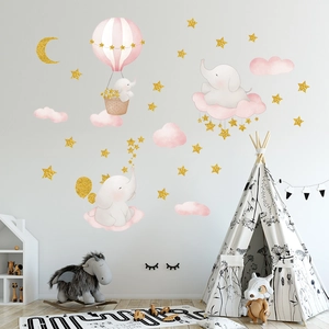 Détail de montgolfière rose et stickers muraux éléphants dorés dans une chambre d'enfant