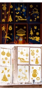 Detail of glitter gold Christmas window stickers featuring Santa, reindeer and snowflakes