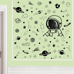 Detail showing black astronaut and stars wall decals on a minimalist green wall
