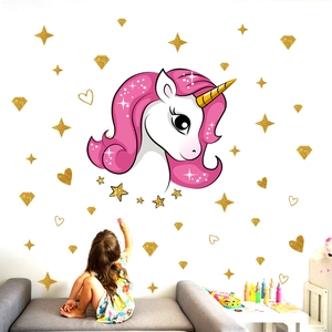 Unicorn wall decal with gold glitter stars and hearts in a kids' bedroom setting