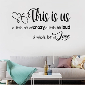 Detail showing 'This is us' vinyl wall decal with family quote over a sofa