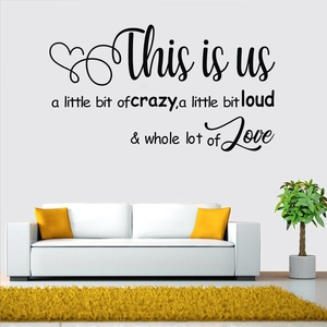 Detail of 'This Is Us' vinyl wall decal with family quote over a modern white sofa