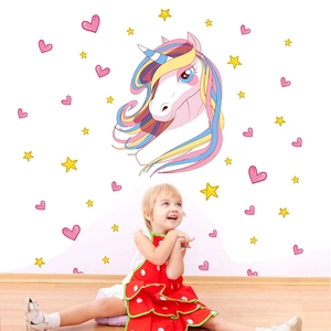 Close-up of unicorn wall stickers with stars and hearts in a cozy children's bedroom decor
