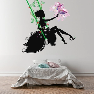 Detail of fairy wall sticker with butterfly swing over a cozy bedroom bed setup
