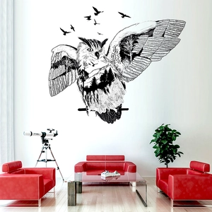 Artistic owl silhouette wall sticker with forest interior above a red sofa in living room
