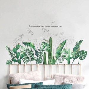 Detail of tropical plant wall stickers with poetic text on a bedroom wall surface
