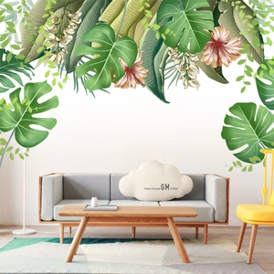Tropical monstera and palm leaf wall decals in a modern living room setting