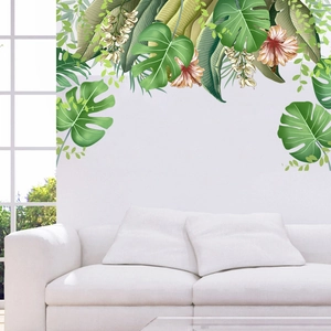 Detail of tropical monstera leaves and hibiscus wall stickers on a clean white wall