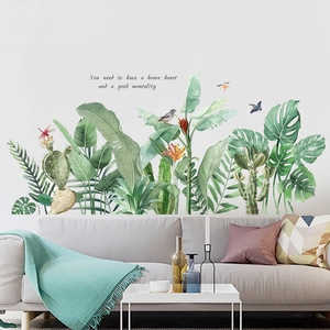 Detail of tropical plant wall stickers with green leaves, birds, and an inspiring quote